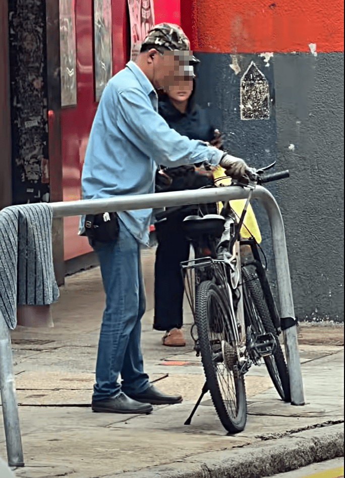 男子靠近一部自行车。fb：的士司机资讯网 Taxi