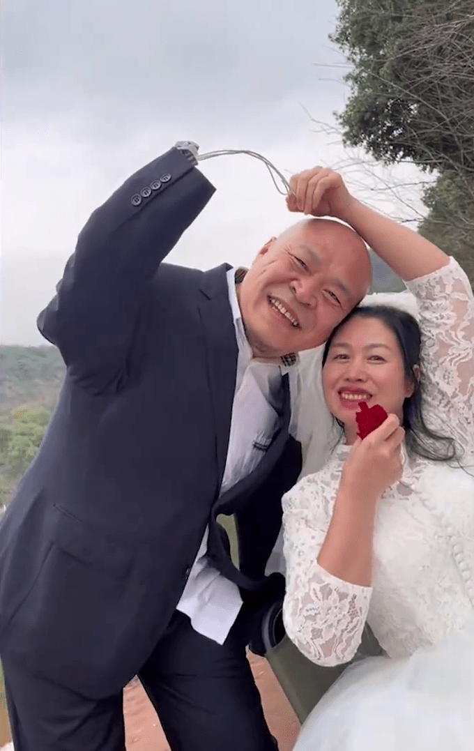 黄国富与妻子拍婚纱照，一起比心。