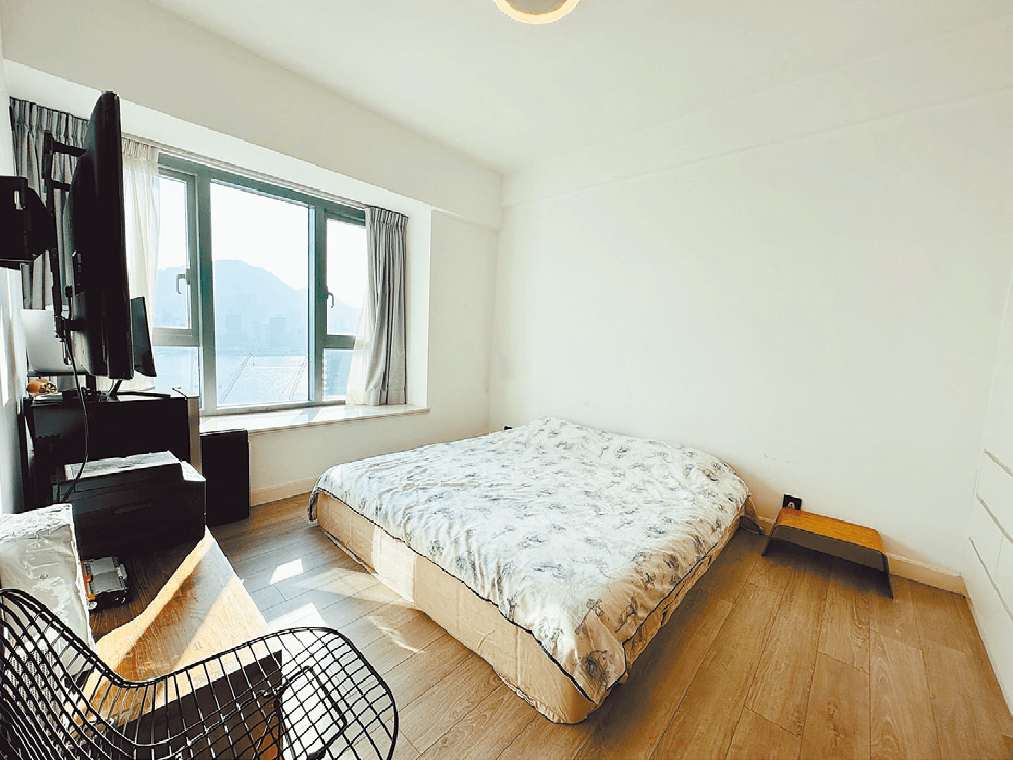 圖中睡房以白色為主調，簡約清新，同時能營造出空間感。