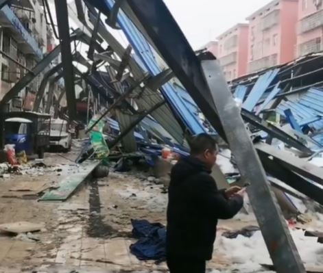 菜市场严重损毁，救援人员仍在搜索被困者。影片截图