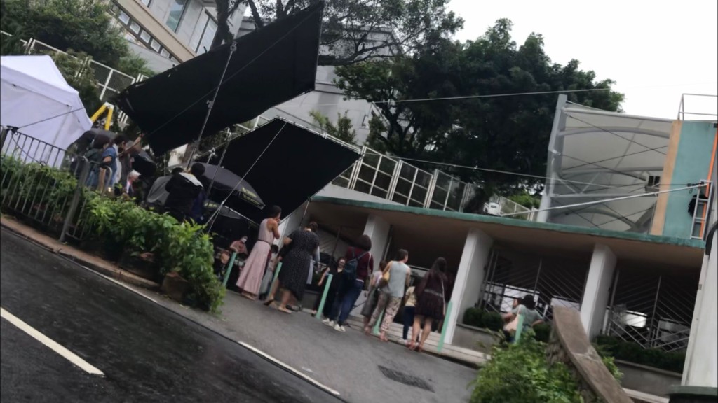 周日上午9時許,妮歌先乘車到山頂小學開工,現場所見劇組人員甚多,戶外亦設置了多個帳幕,十分大陣仗。