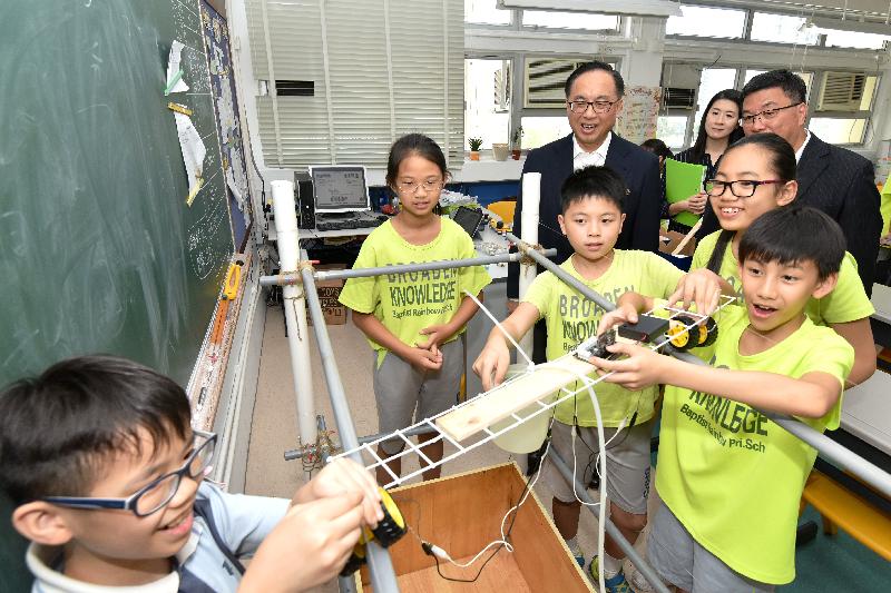 楊偉雄(後排左)在浸信會天虹小學觀看學生參與自主學習活動。政府新聞處圖片