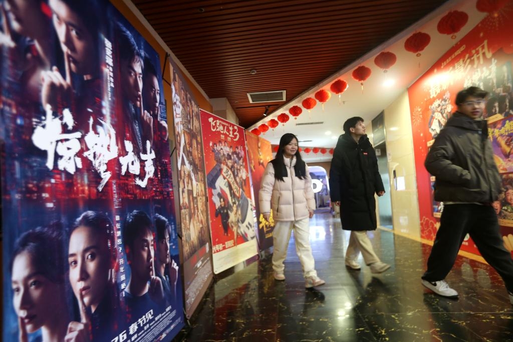 2月23日，在江苏省连云港市连云区一家影城，观众从电影海报旁走过。新华社