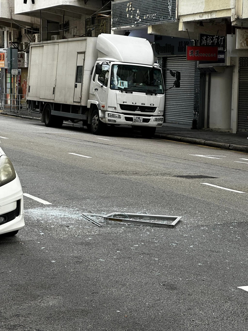 一扇铝窗从高处堕下，击中一辆停泊在路边的私家车。网上图片