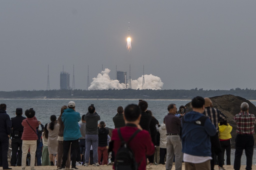 遊客在文昌海邊觀看火箭發射。