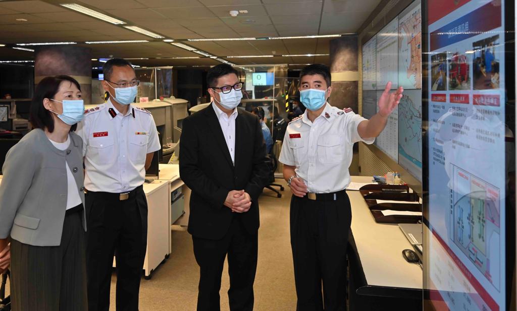 鄧炳強到訪消防通訊中心，觀看中心人員示範使用調派後指引系統。