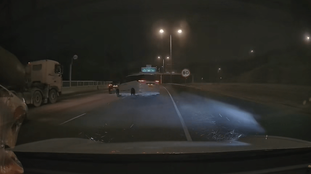 隨即「擺尾」反彈，如「打波子」般橫跨全部三條行車線，猛烈撞向左邊路壆，現場揚起大量沙塵。