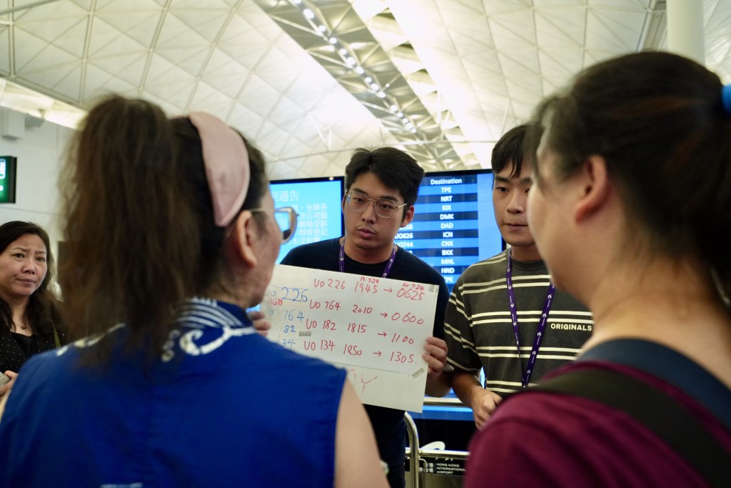 今日有航空公司职员用手写牌安排乘客登机。刘骏轩摄