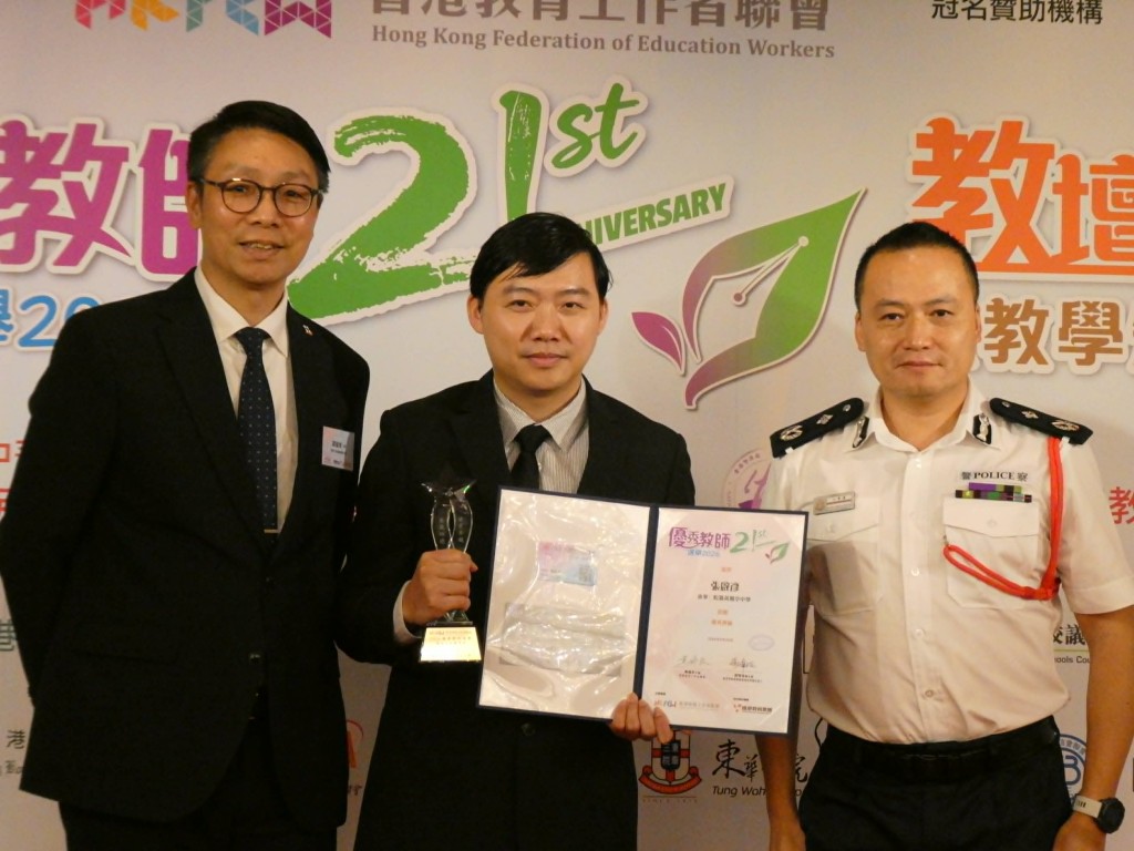 新設的「國安教育組」獎項，由警方國安處處長江學禮（右）頒發，張啟彥（中）獲譚耀華（左）陪同上台領獎。歐文瀚攝