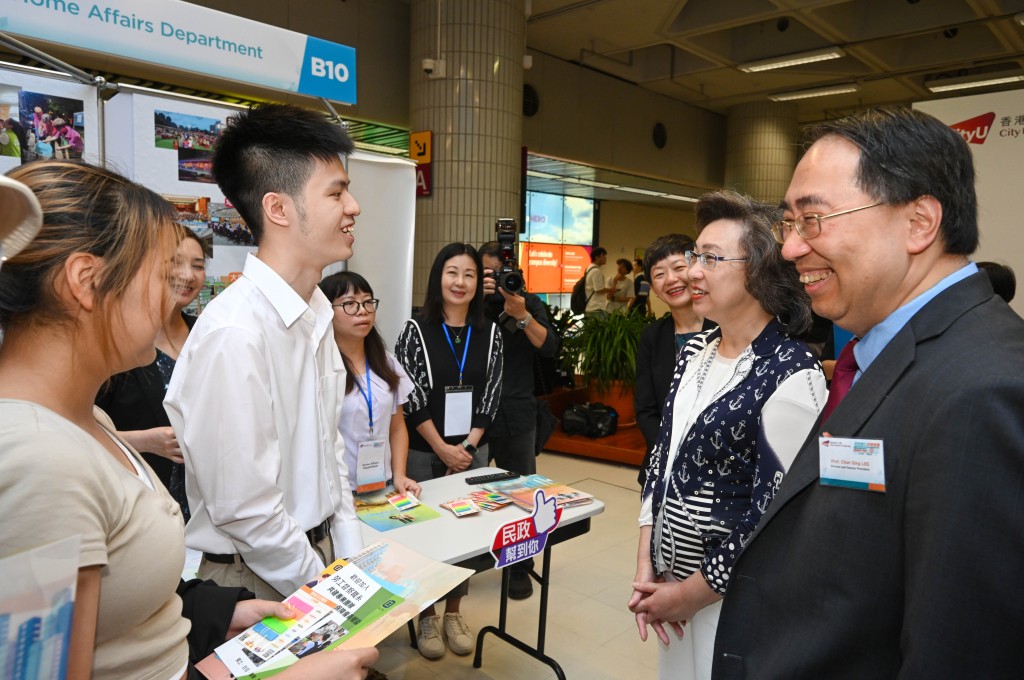 杨何蓓茵（右二）与城大首席及常务副校长李振声（右一）在招聘展览与学生倾谈。政府新闻处