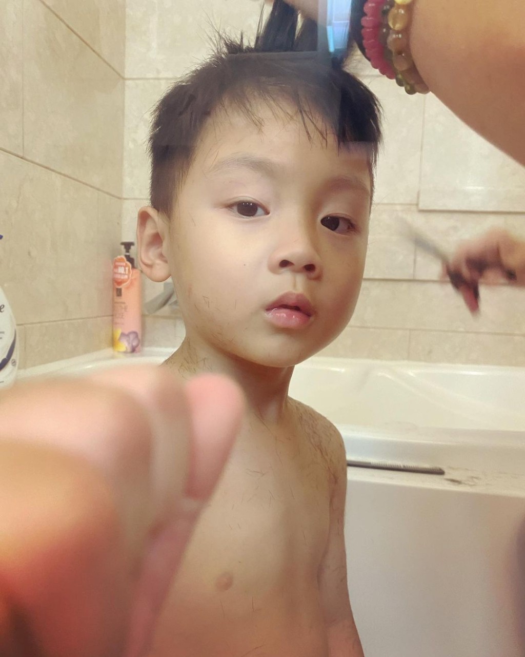 囝囝的身上滿佈頭髮碎。