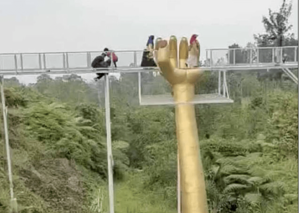 网上视频可见，有游客成功抓住桥架，下半身悬挂桥下。