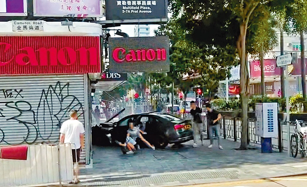 私家車撞向地鋪後,其中一名女乘客逃出車廂時失平衡仆倒地上。