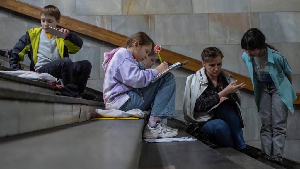 基辅响起空袭警报，民众躲进地铁站避难。学生在站内继续上课。 路透社