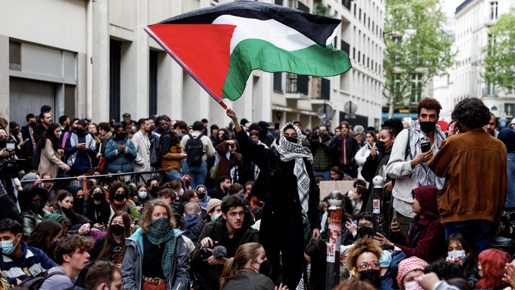 年轻人占领巴黎政治大学大楼前的一条街道，对加沙的巴勒斯坦人表达支持。  路透社