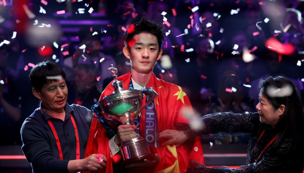 吴宜泽夺冠后，父母为儿子披上国旗。新华社