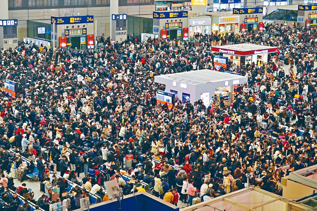 旅客們5日在上海虹橋火車站等車。