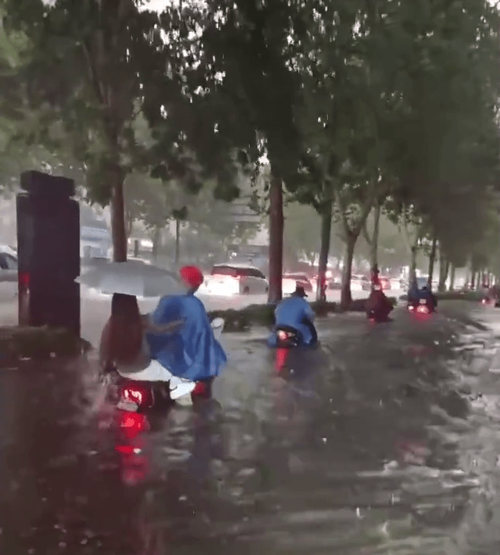 郑州22日的暴雨下，市民驾驶电动车艰难前进。