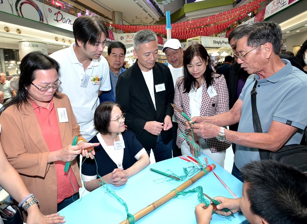 開幕典禮嘉賓參觀展覽及工作坊，環境及生態局副局長黃淑嫻 (中坐者) 對編織魚網的技術甚感興趣。