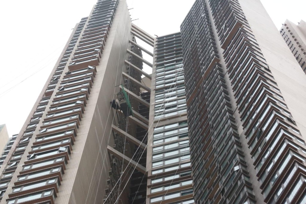 吊船在高空傾側，兩工人被困半空。