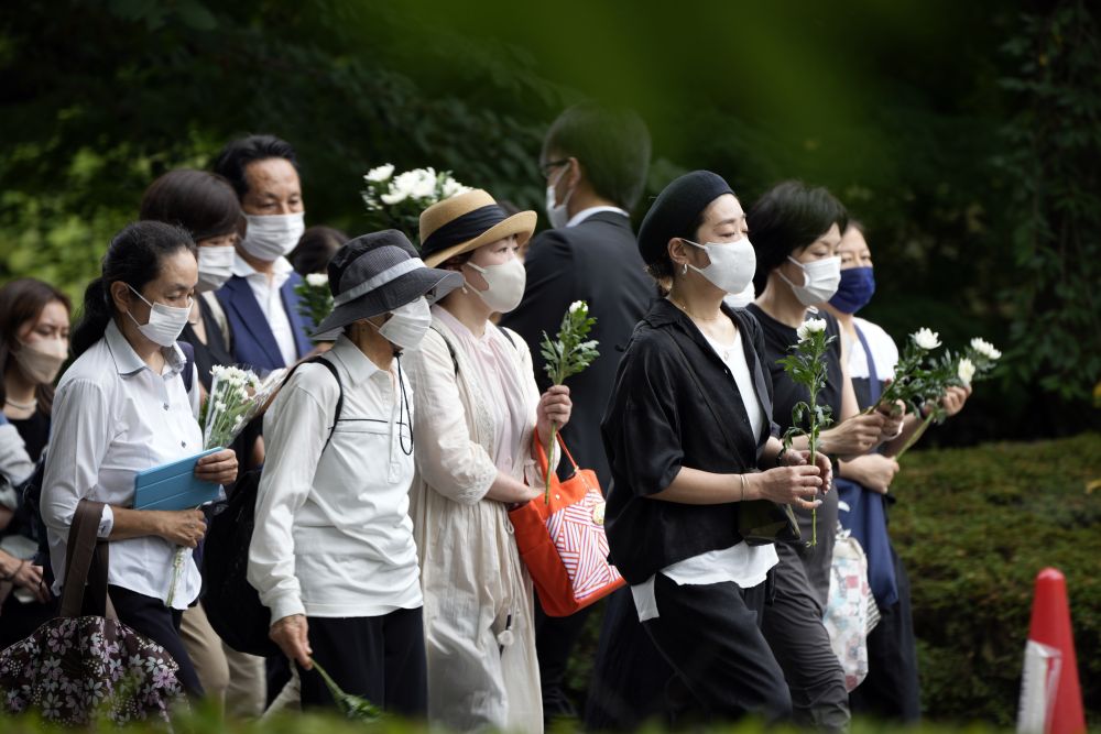 日本民眾在增上寺前為安倍晉三獻花和祈禱。AP圖