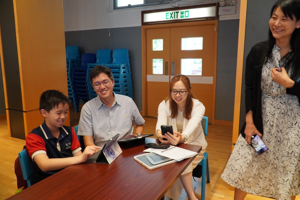 九龍城浸信會禧年小學四年級學生香同學（左一）與家長一同出席工作坊，他認為AI有助主動尋找答案，幫助學習。