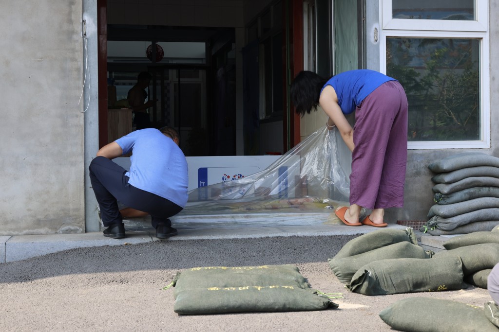 8月11日,北京通州,宋莊低窪住戶居民在暴雨來臨之前構築沙袋防雨水倒灌。當日北京多區發佈暴雨紅色預警。中新社 8月11日,北京通州,宋莊低窪住戶居民在暴雨來臨之前構築沙袋防雨水倒灌。當日北京多區發佈暴雨紅色預警。中新社