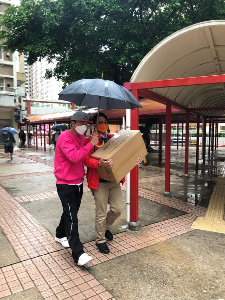 杨明为邓家彪撑伞挡雨。邓家彪fb图片