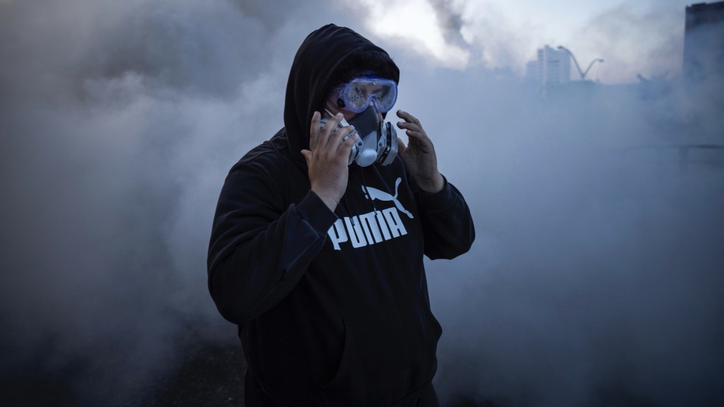 洛杉磯示威者戴面罩對抗催淚煙。 美聯社 洛杉磯示威者戴面罩對抗催淚煙。 美聯社