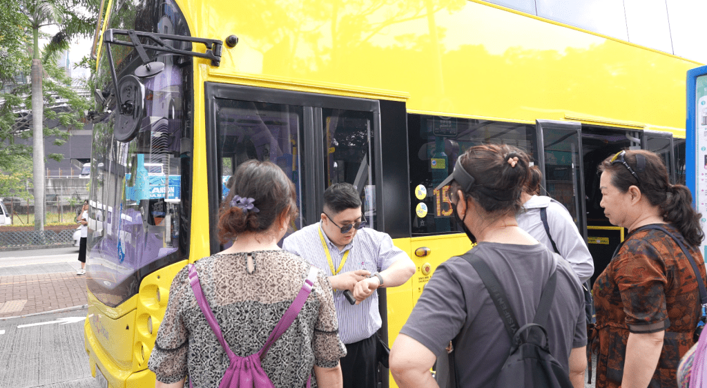 沃大地車長幫內地旅客查詢巴士開出時間。