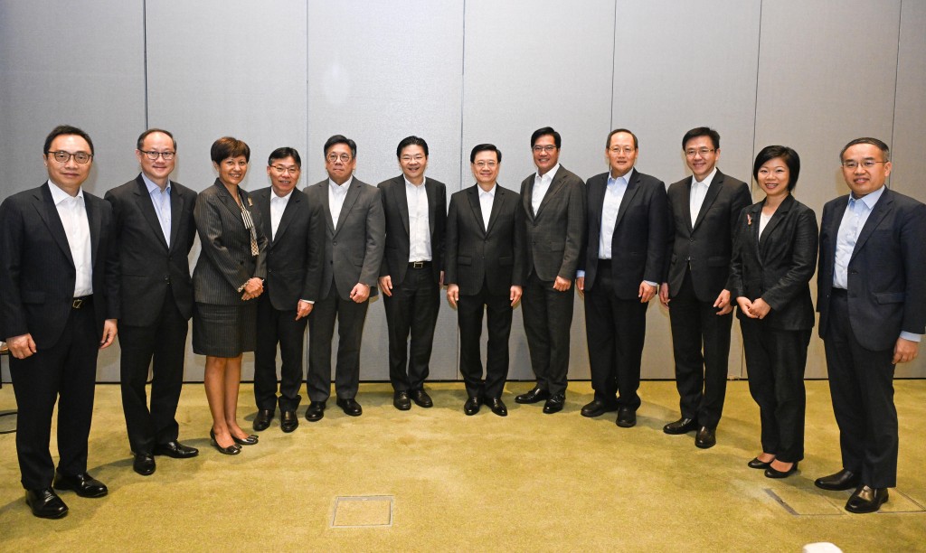 行政长官李家超7月24日在新加坡与新加坡副总理兼财政部长黄循财举行早餐会议。图示李家超（右六）和黄循财（左六），以及两地官员合照。（政府新闻处）