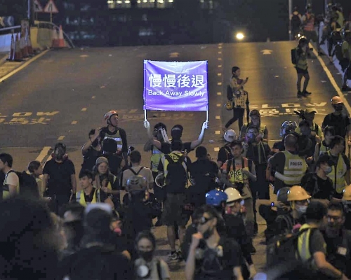 有人高舉「慢慢後退」標語,呼籲市民離開。