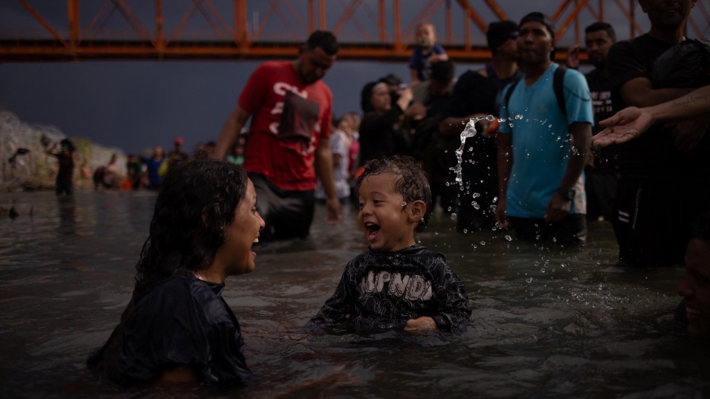 成功抵達美國境內的委內瑞拉19歲女子與一名2歲同路小孩玩水，他們正等着與數百人一起自首。 路透社