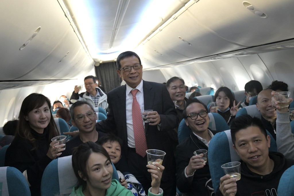 許漢忠與乘客舉杯，慶祝航班啟航。梁譽東攝