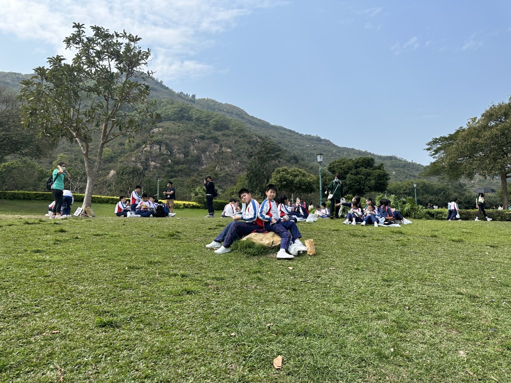 活力午餐．学生分批坐在野餐塾上享用自备膳食。(梁国峰摄)