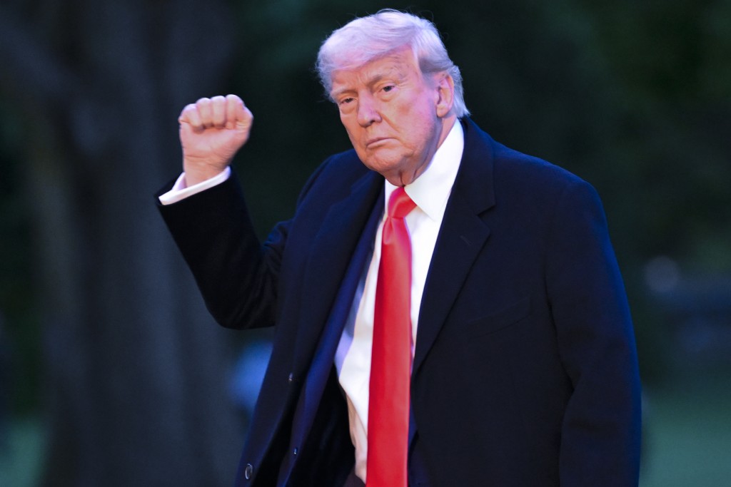 特朗普迷因币$TRUMP买家参加晚宴，特朗普到场高举拳头示意。美联社