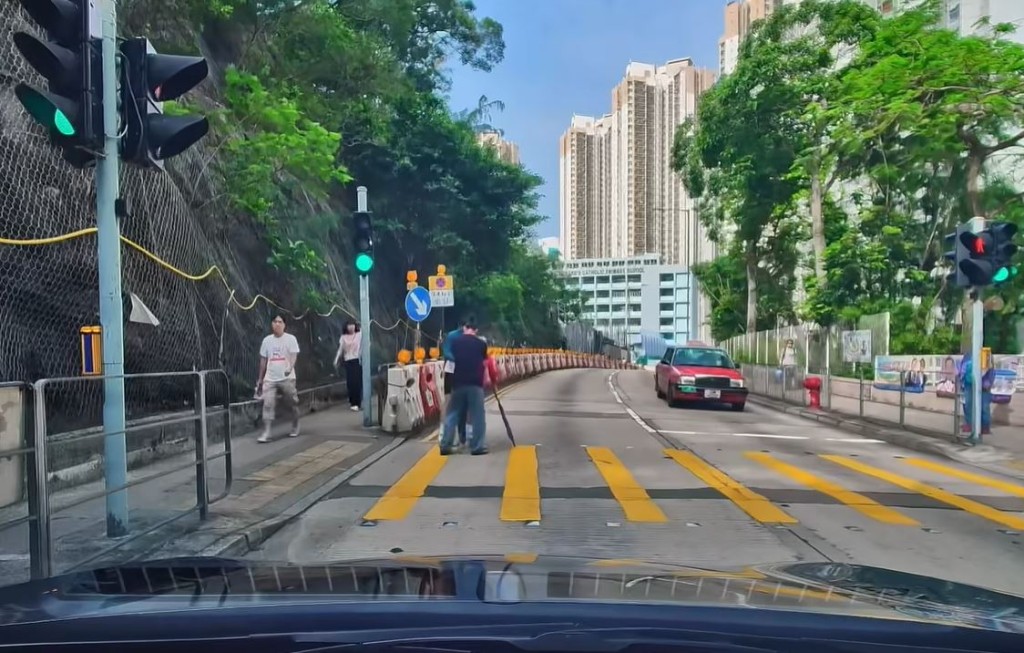 兩男將婆婆扶返行人路。fb「車cam L（香港群組）」影片截圖