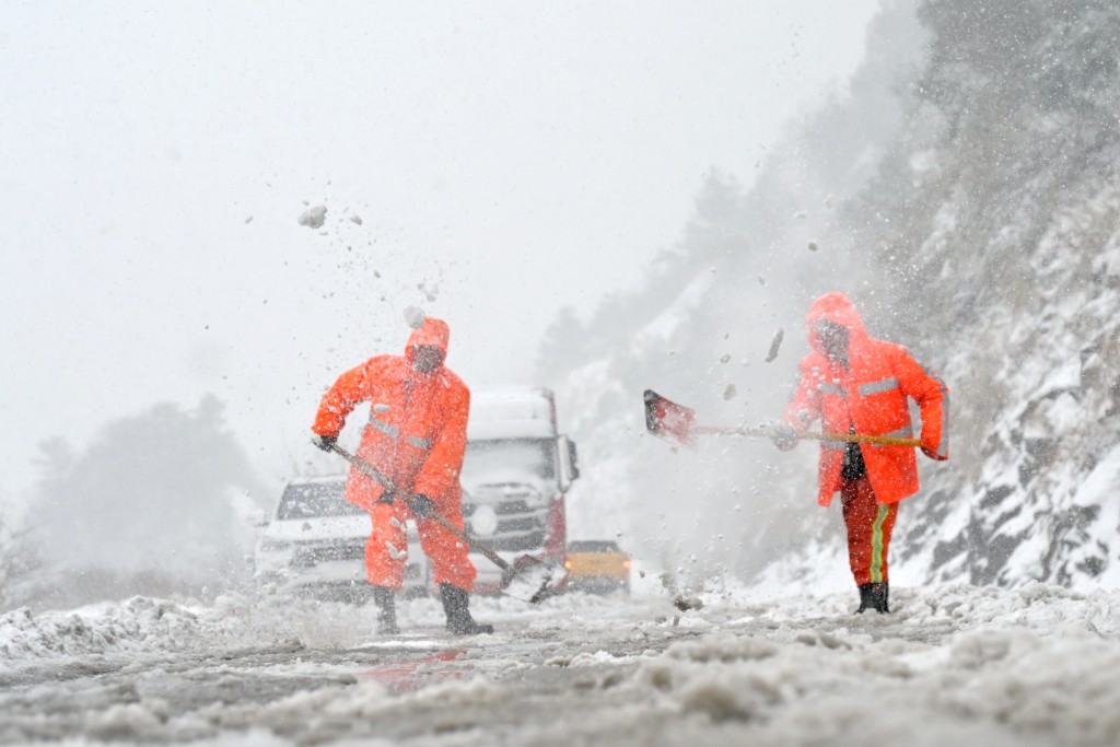 湖南工人加緊清除道路積雪。新華社