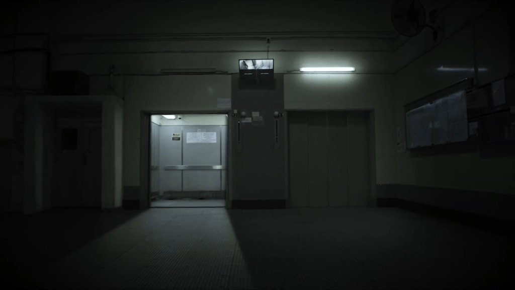 影着工厦电梯门自动打开，里面空无一人。