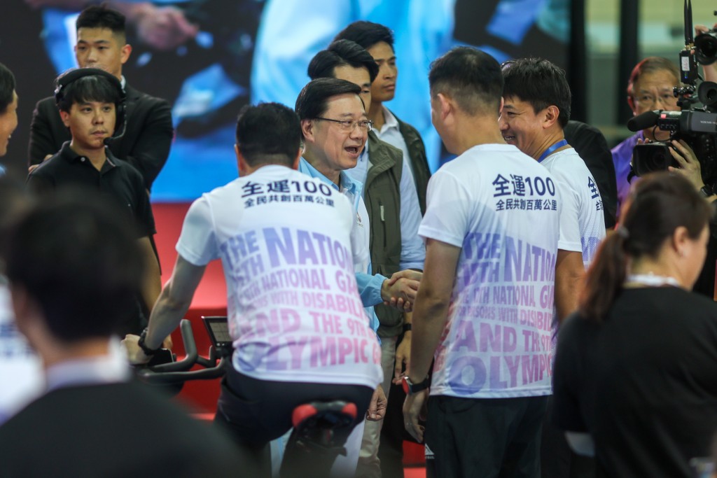 李家超為完成「全運100全民共創百萬公里大挑戰」最後100公里的選手打氣。何家豪攝