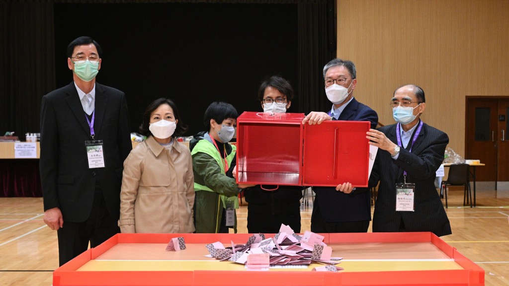 陸啟康法官（右二）、麥美娟（左二）、陸貽信資深大律師（右一）和石丹理教授（左一）在將軍澳順德聯誼總會梁潔華小學的點票站内，倒出投票箱中的選票。 政府新聞處圖片