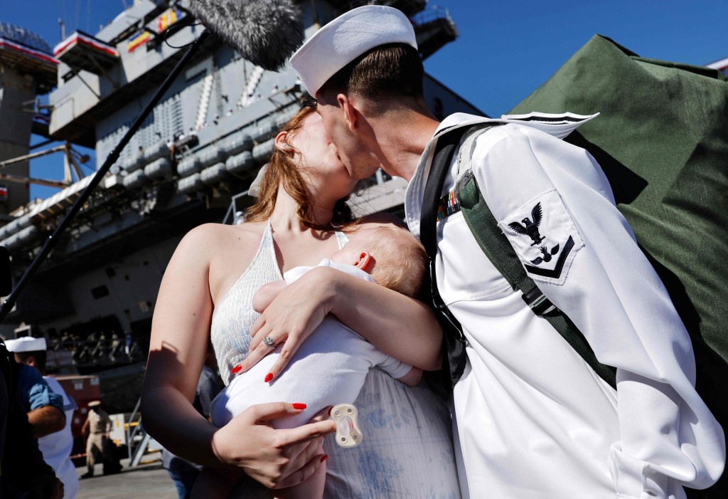 一名水兵的妻子抱著新生兒迎接丈夫歸來。法新社 一名水兵的妻子抱著新生兒迎接丈夫歸來。法新社