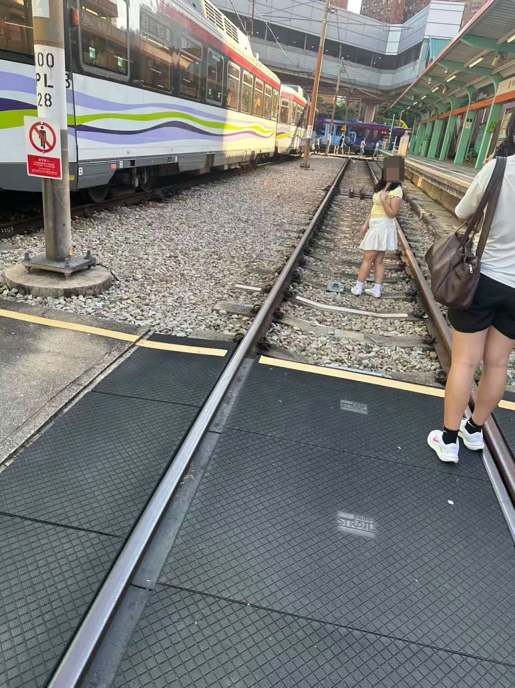 女子闖入輕鐵路軌拍照時,右側的月台剛巧有列車停靠。網上圖片 女子闖入輕鐵路軌拍照時,右側的月台剛巧有列車停靠。網上圖片