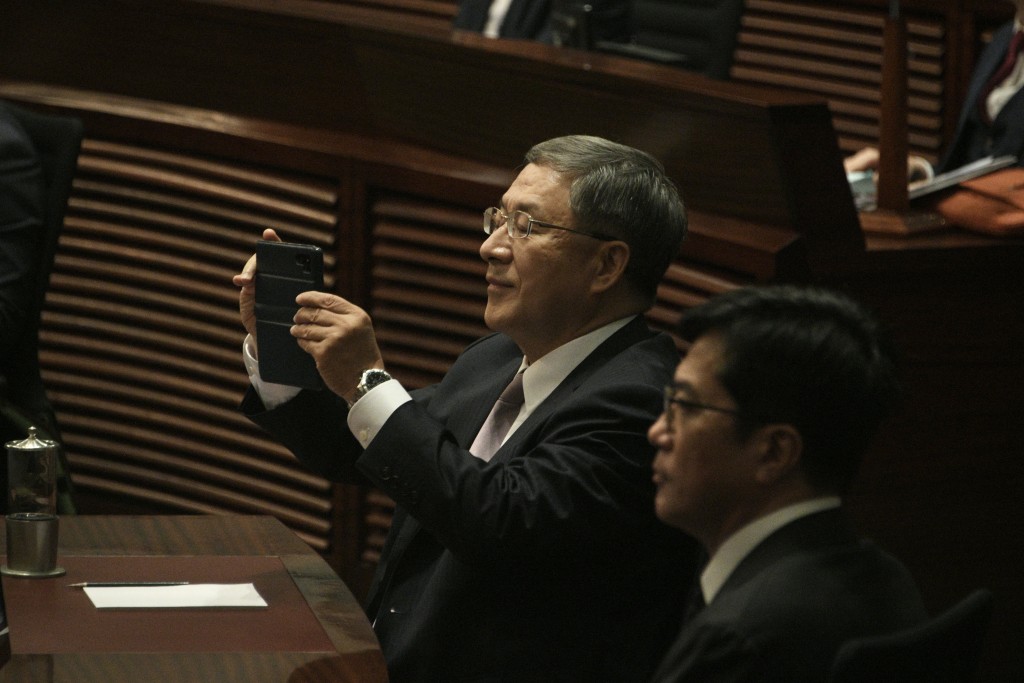 政务司副司长卓永兴同样举起手机拍下历史一刻。