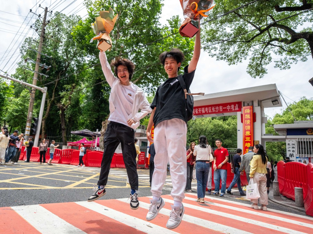 考生兴奋地在试场外留影。新华社