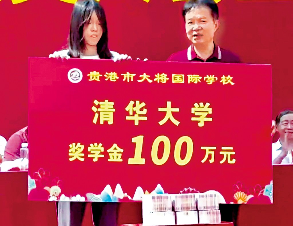 女生接過百萬元獎金。