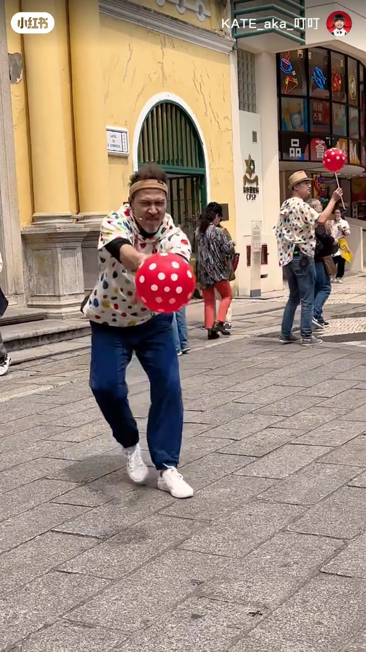 Julio拉着氣球像小丑表演，與圍觀的小朋友互動。  ​