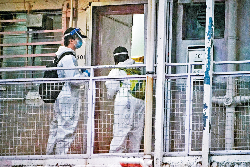 ■穿防護衣人員上門查核住戶資料。 ■穿防護衣人員上門查核住戶資料。