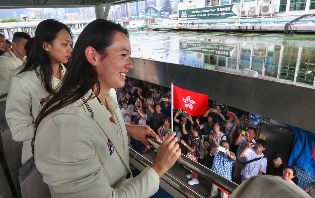 运动员在巴士上向巿民挥手。联合采访图片