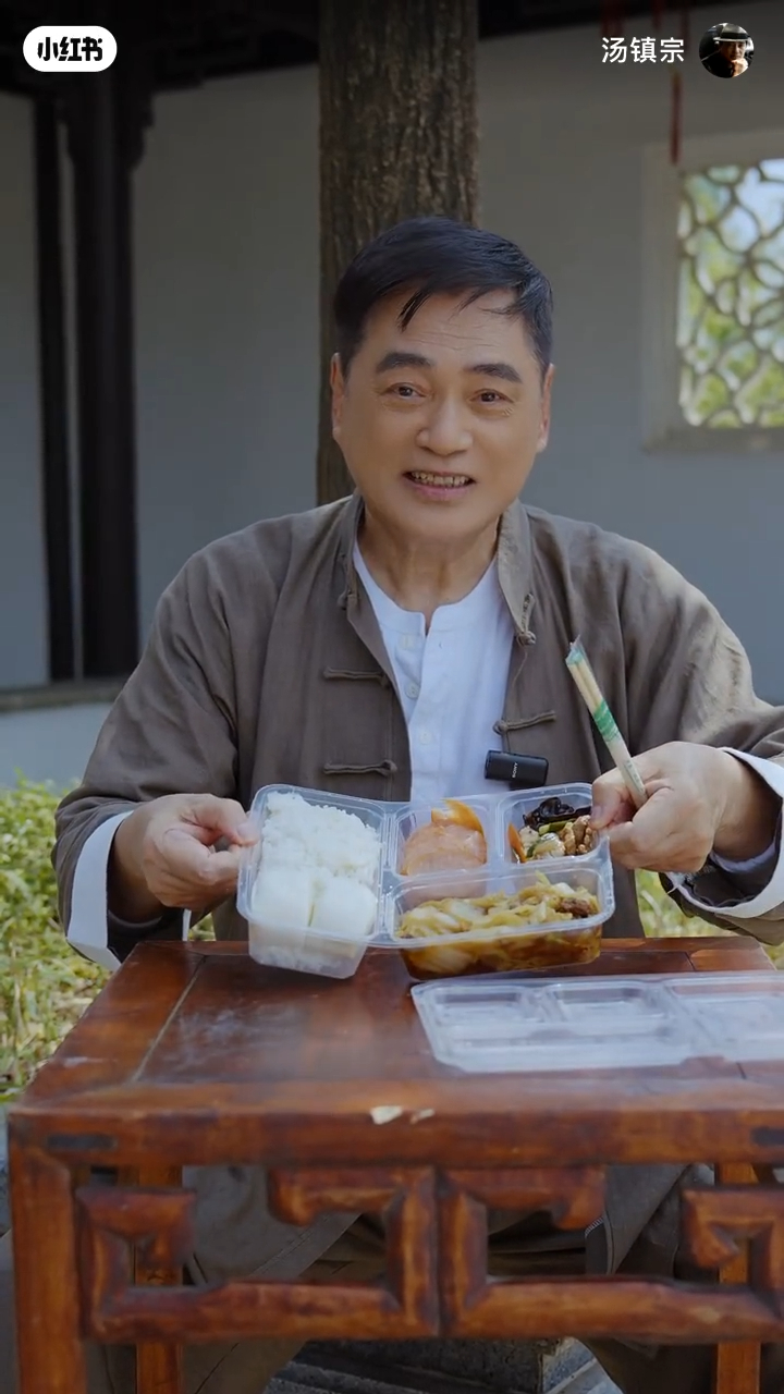 湯鎮宗毫無明星架子,大方捧起劇組派發的平民「三餸飯」。 湯鎮宗毫無明星架子,大方捧起劇組派發的平民「三餸飯」。